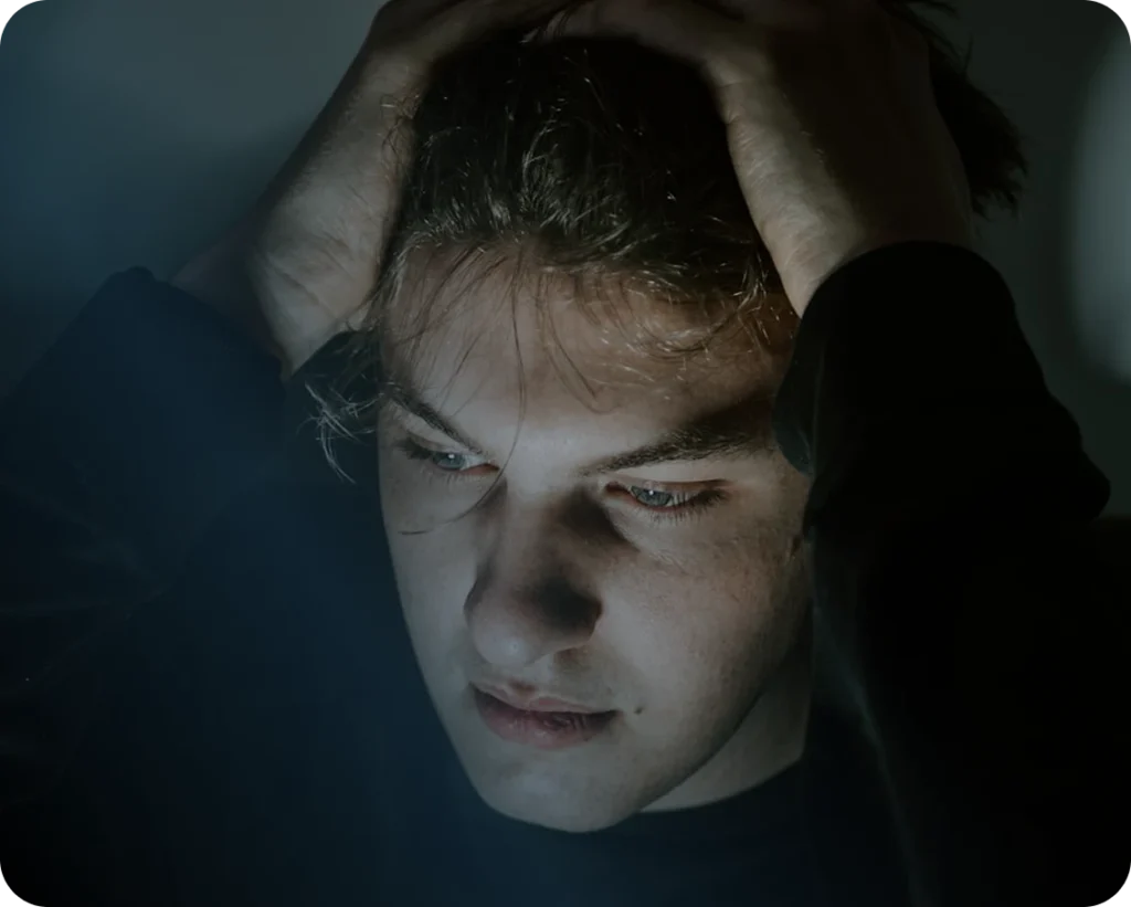 A man with his hands on his head and a worried expression.