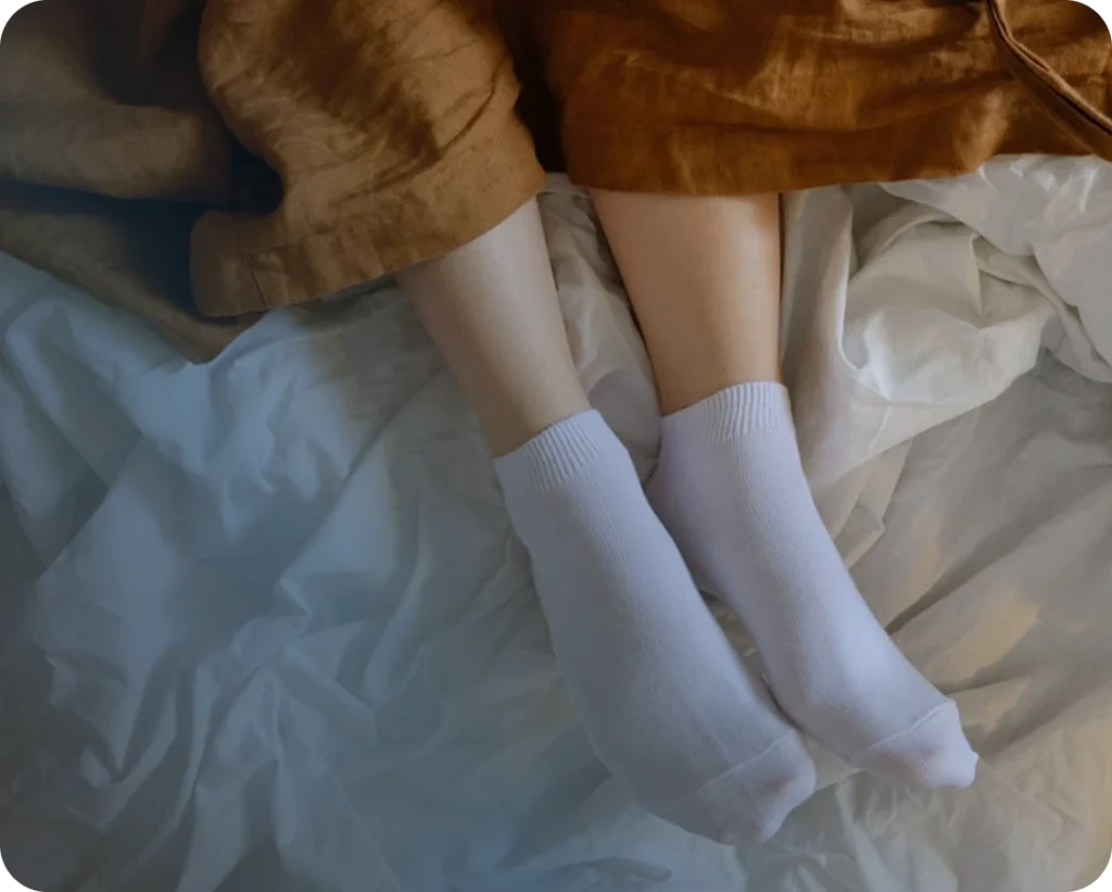 A woman's legs over a bed